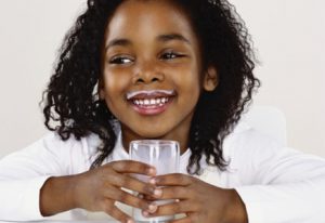 Criança tomando leite para prevenir a gripe