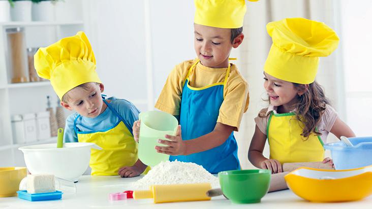 a criança faz um jogo infantil - o cozinheiro prepara a comida